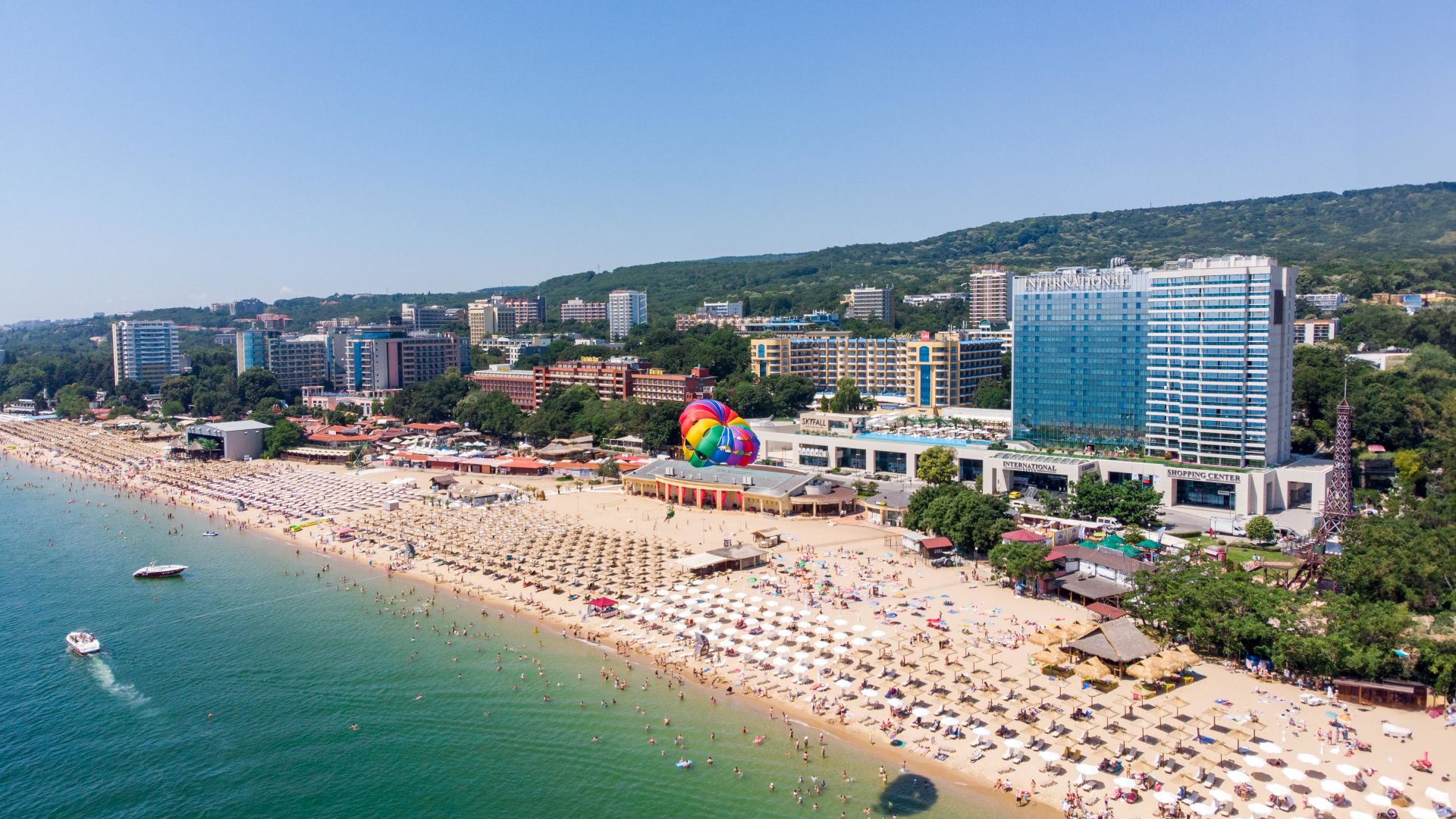A Beach With Many People And Buildings